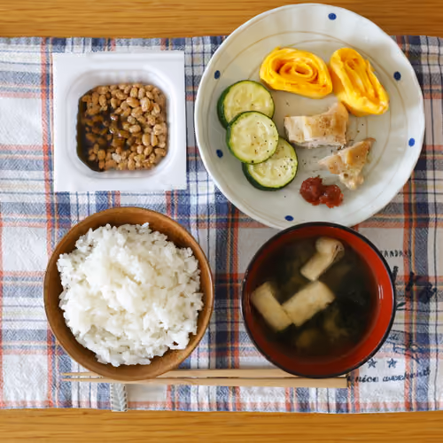 2026-07-11 の朝食（ごはん、納豆、卵焼き、ズッキーNIのソテー、焼き鶏、梅干し、味噌汁）