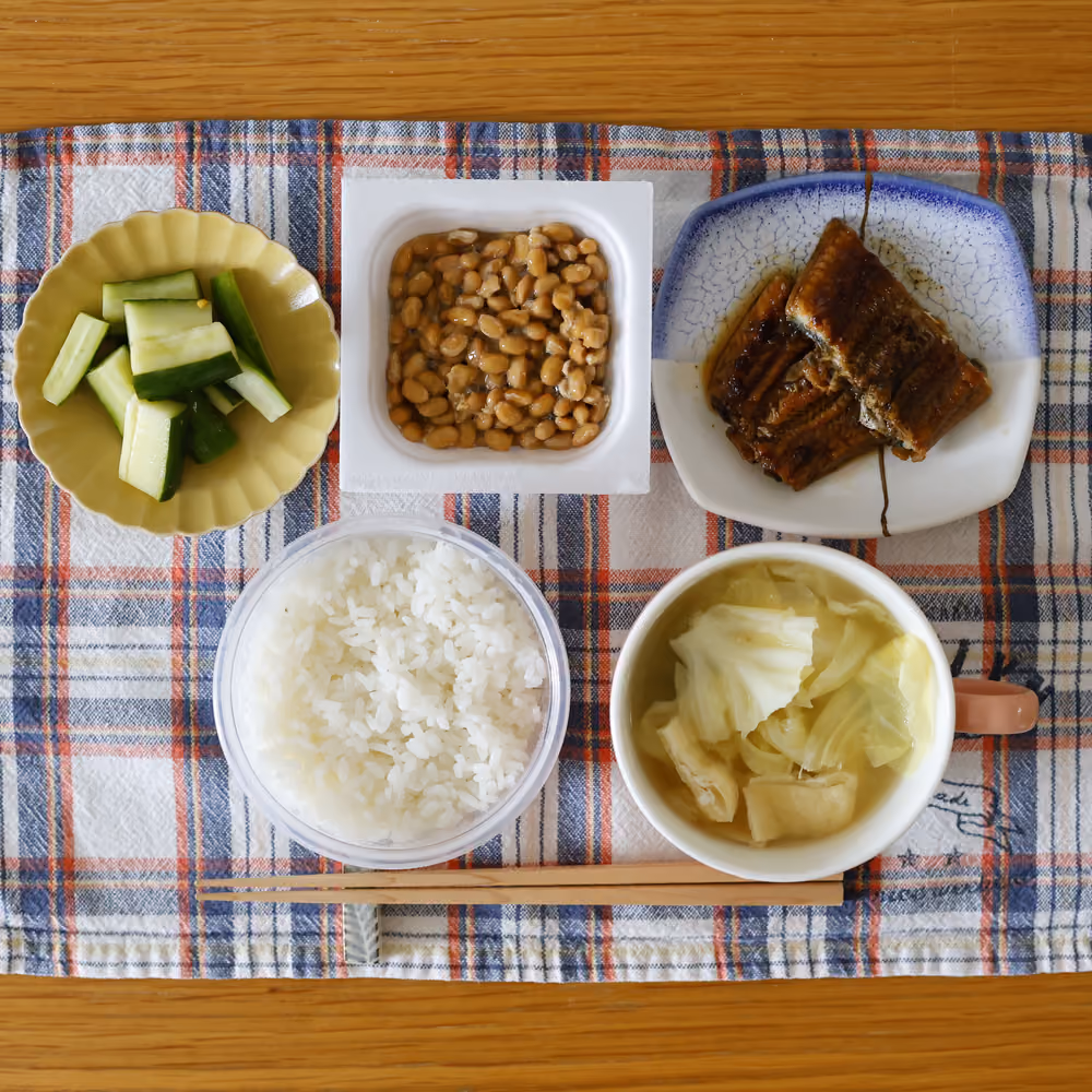 ごはん、納豆、きゅうりの漬物、うなぎの蒲焼、キャベツと油揚げの味噌汁