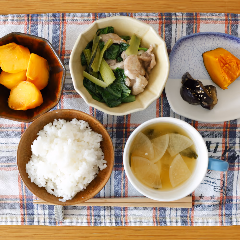 ごはん、大根のスープ、小松菜と豚肉の炒め物、かぼちゃの煮物、なすの煮浸し、柿