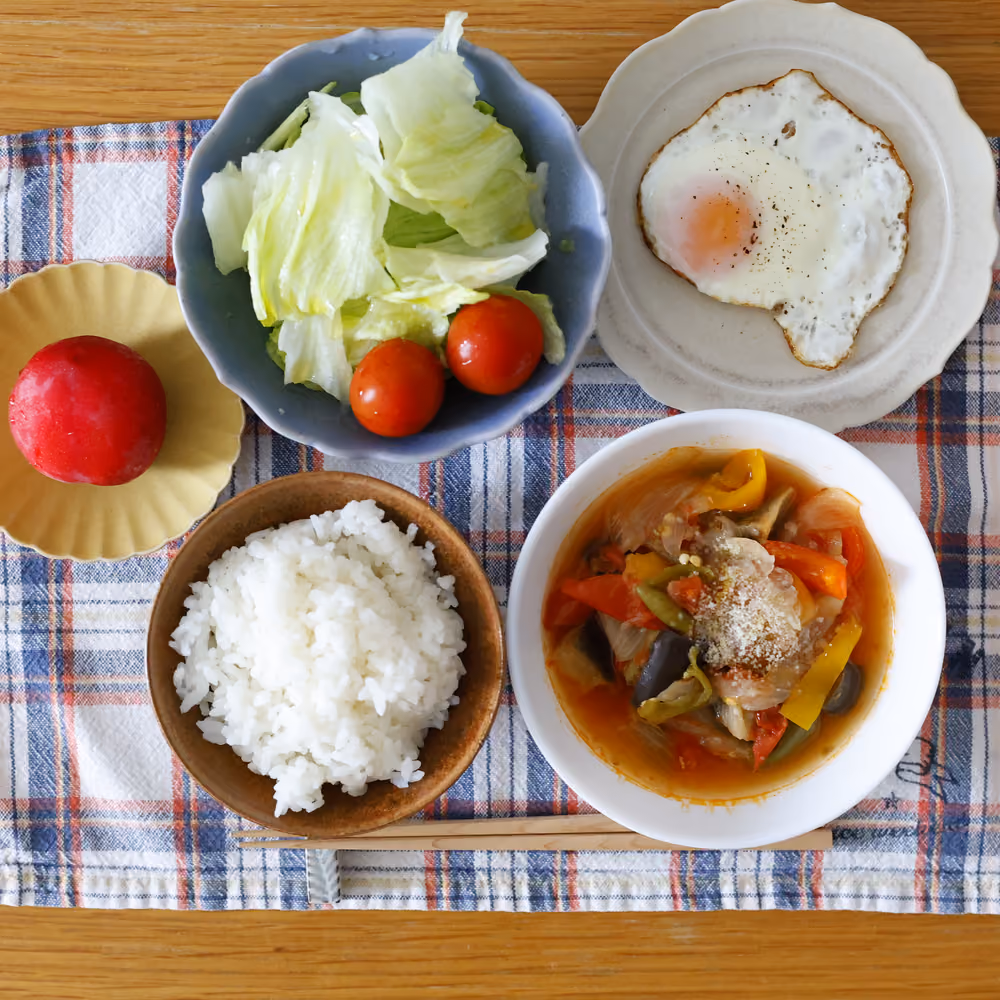 ごはん、目玉焼き、レタスとミニトマトのサラダ、野菜のトマトスープ煮、すもも