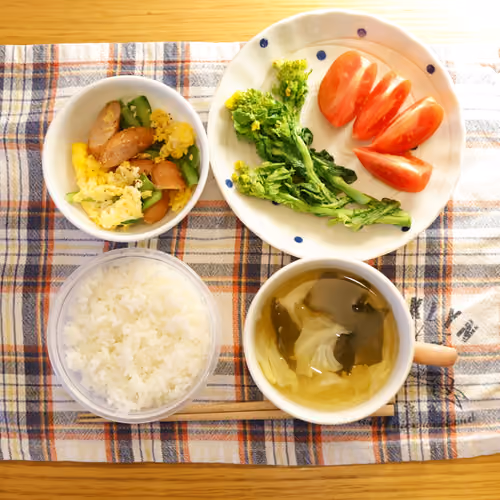 2026-04-07 の朝食（ごはん、ソーセージと卵ときゅうりの炒め物、菜の花、トマト、わかめと野菜のスープ）
